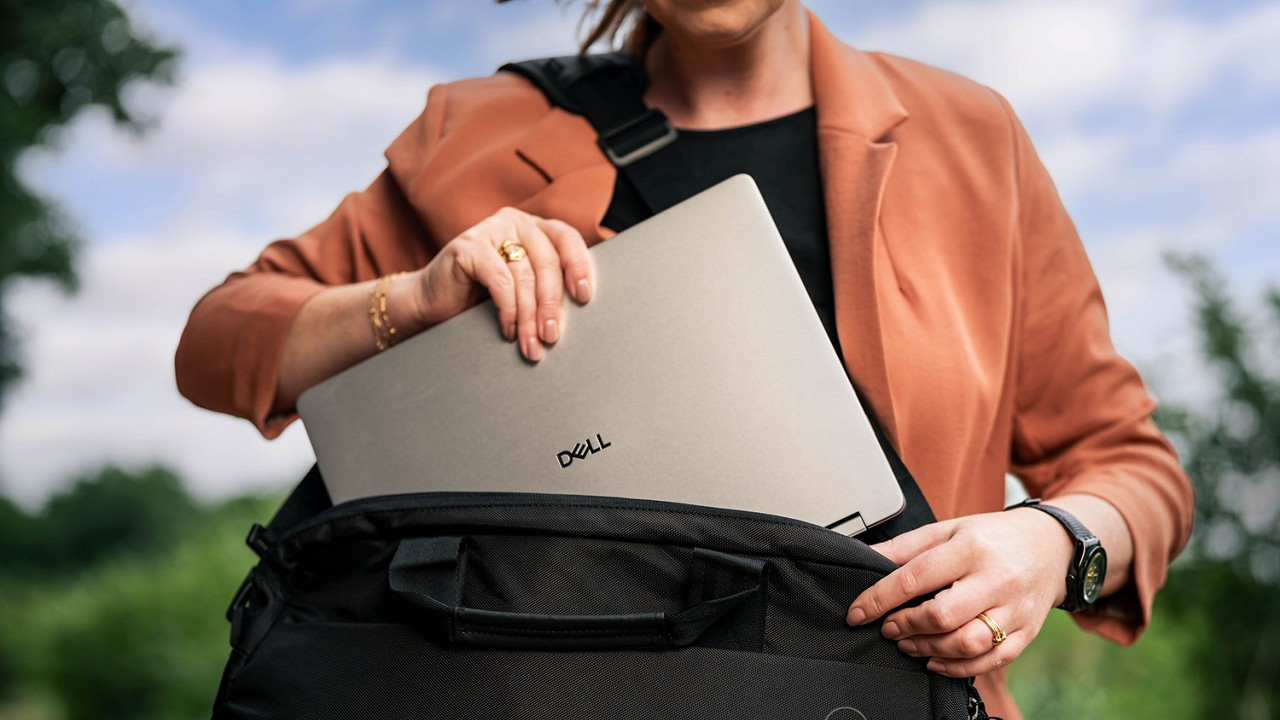 A Dell Plus laptop being used in a coffee shop, showcasing its portability and long battery life.