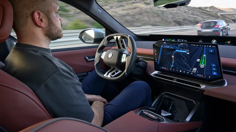 Charging the 2027 BMW iX3 at a public charging station.