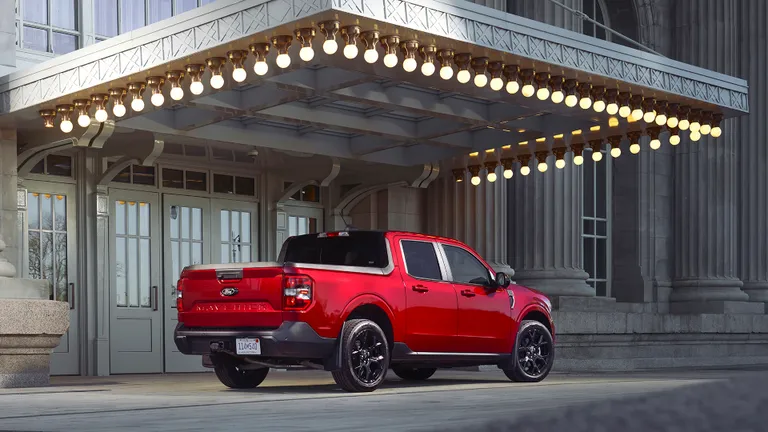 The rear view of the 2026 Ford Maverick, highlighting its practical bed and distinctive taillight design, parked in an urban setting.