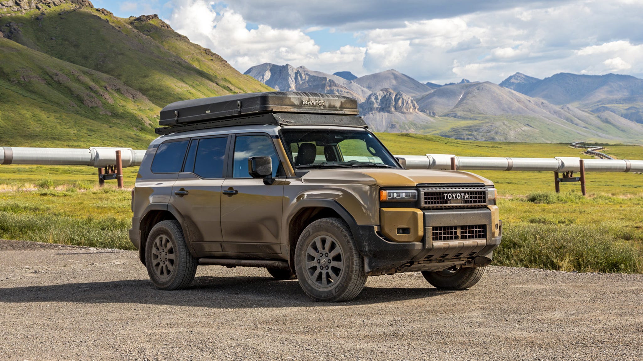 The 2025 Toyota Land Cruiser parked proudly at the iconic 'Welcome to Deadhorse, Alaska' sign, marking the end of an 8,000-mile expedition.