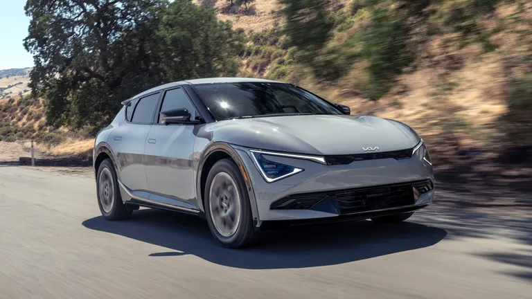 A futuristic concept car with visible sensors for autonomous driving navigating an urban environment, representing the blend of hype and reality in 2025 auto industry trends.