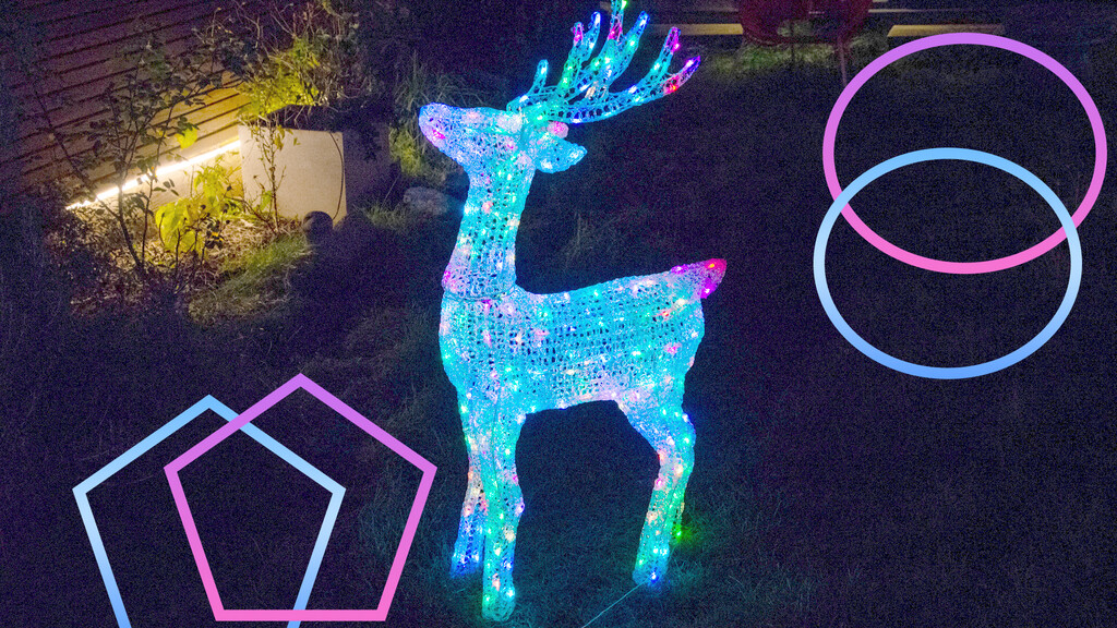 A beautifully decorated house with vibrant smart Christmas lights illuminating the exterior and garden.
